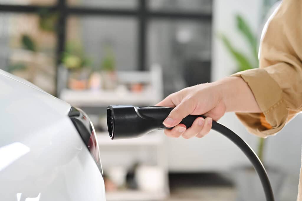 person plugging in an ev charger