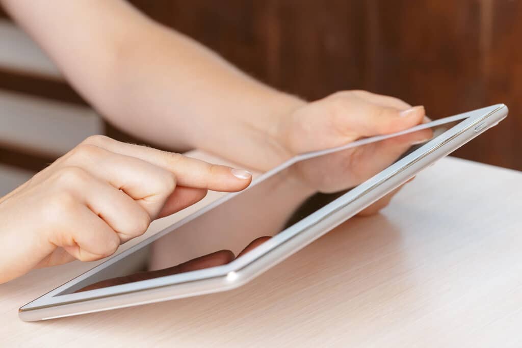 person holding digital tablet