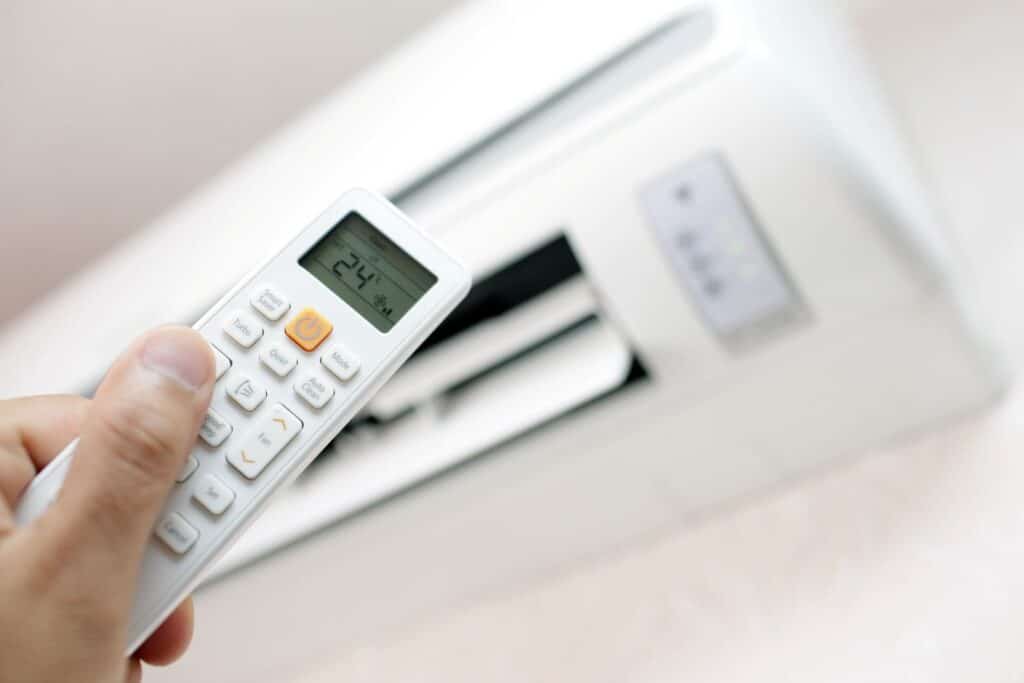 person holding remote for heat pump